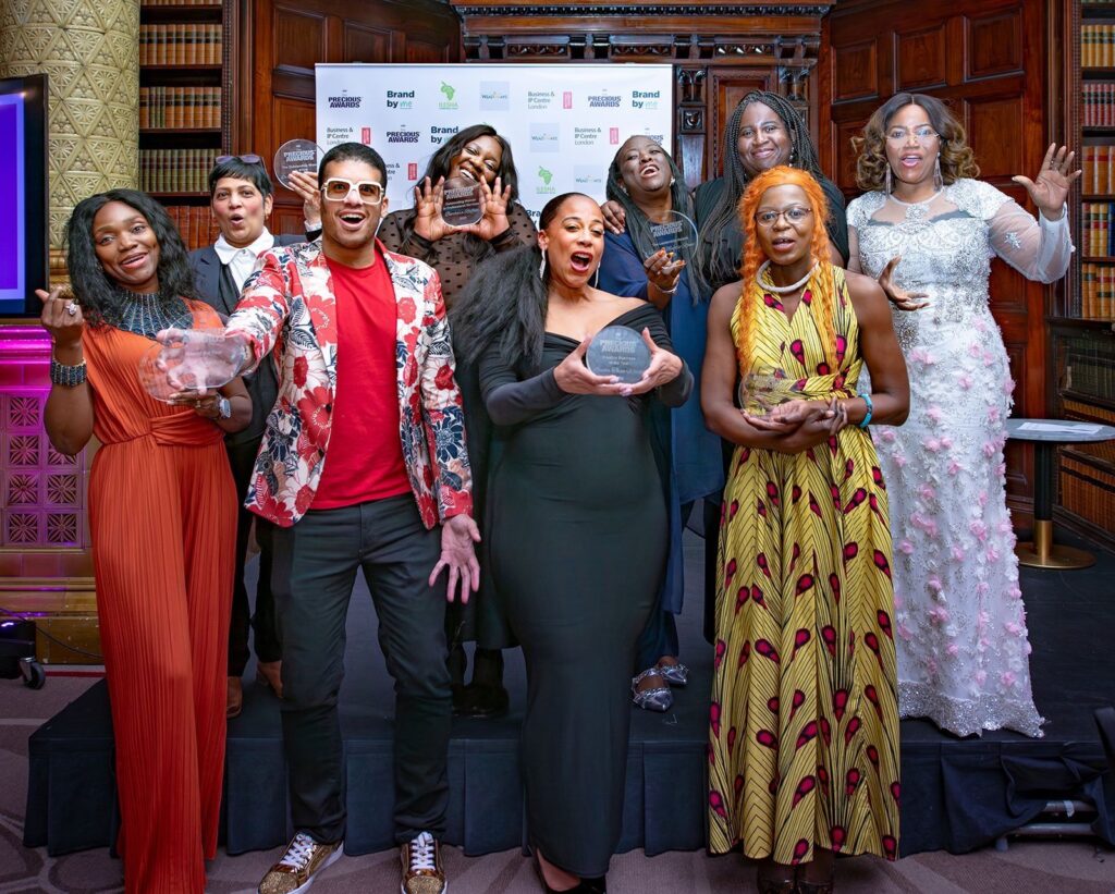 A group of Precious Award Winners having a group photo together holding their awards.
