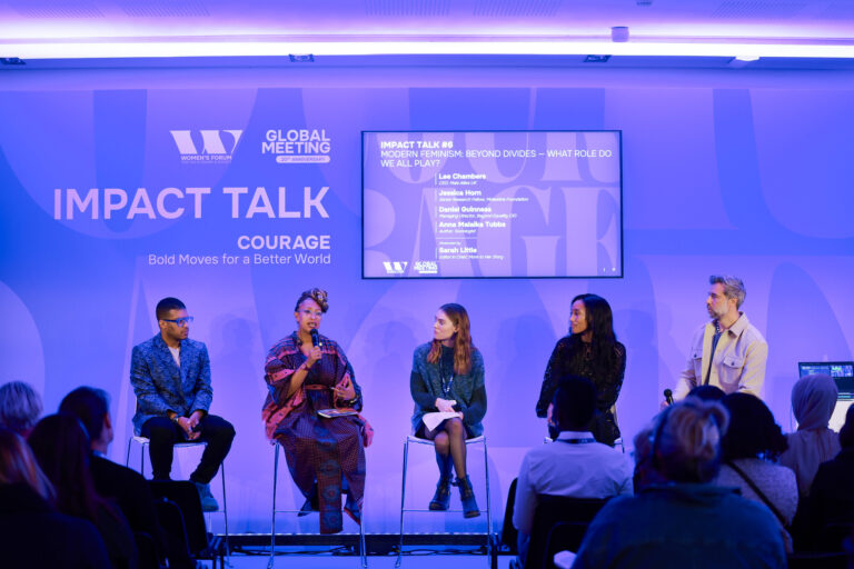 Lee on stage with a panel at the Women's Forum for the Economy *& Society