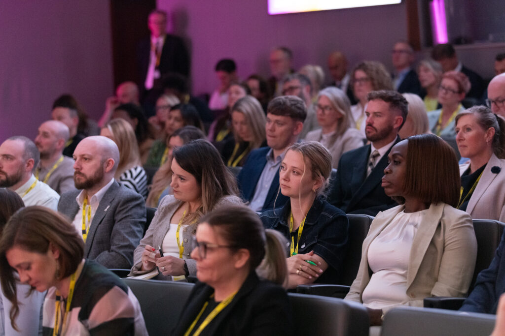 A mixed gender audience photo of the room at the National Allyship Summit